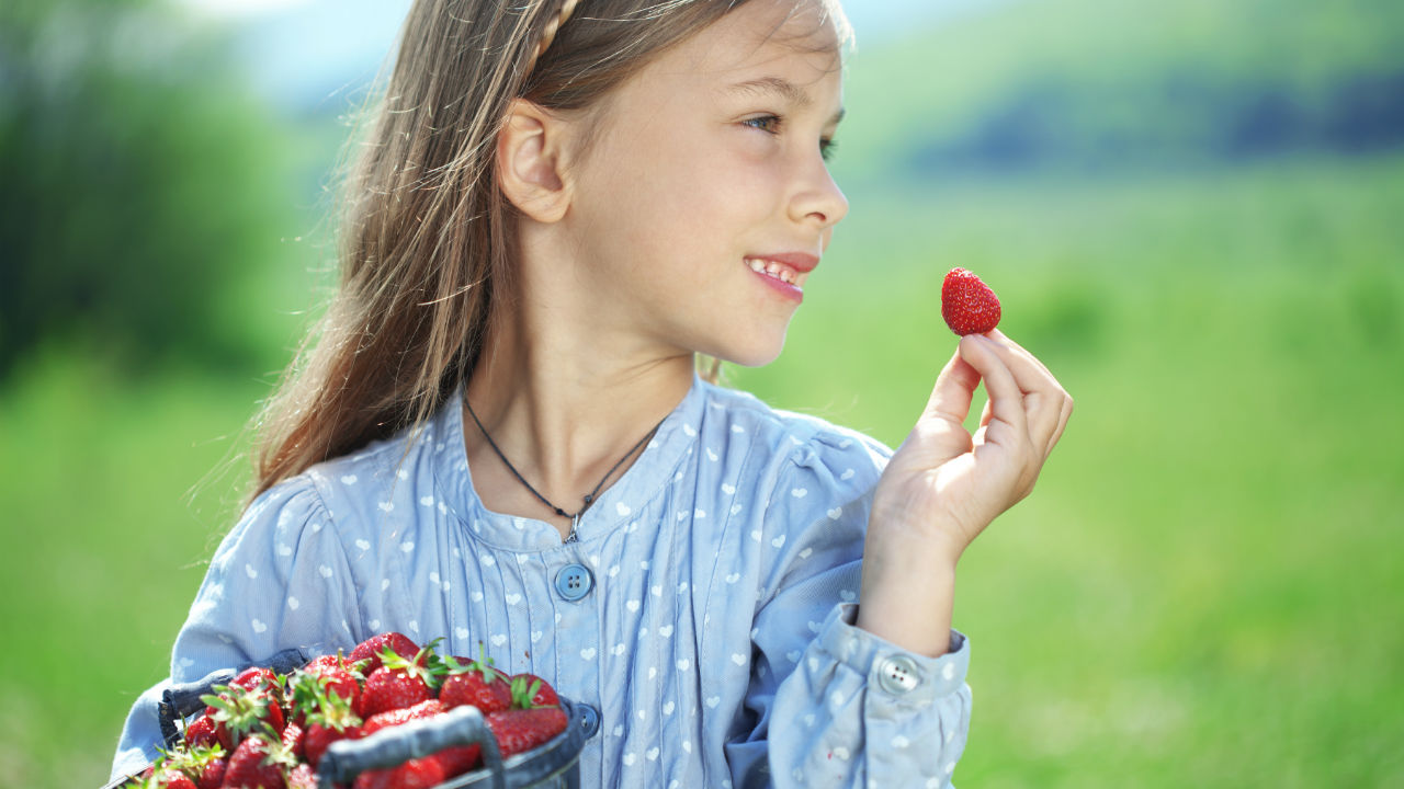 girl holding strawberries